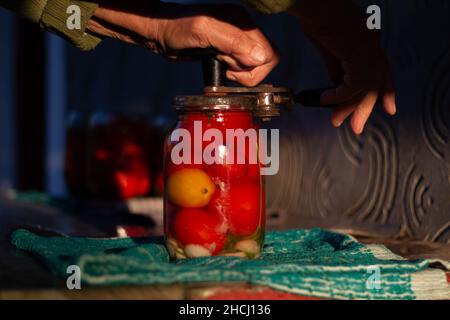 Primo piano di una donna anziana che conserva il pomodoro Foto Stock