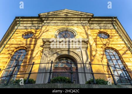 Stoccolma, Svezia - 16 aprile 2021: Ingresso laterale alla chiesa protestante situata nel centro di Stoccolma con facciata gialla al tramonto Foto Stock
