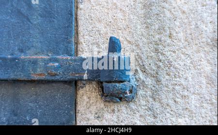 Stoccolma, Svezia - 17 aprile 2021: Cerniera in casta di ferro arrugginita su piccole porte sulla facciata dell'edificio Foto Stock