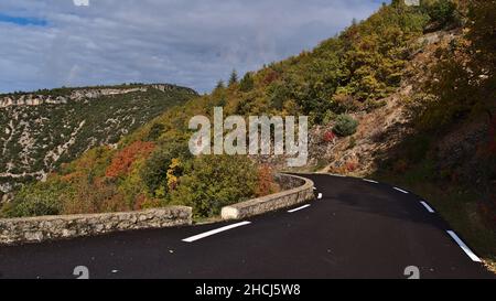 Vista della strada di campagna curvilinea D942 con asfalto nero e marcature bianche sopra le gole del canyon de la Nesque nei Monti Vaucluse in Provenza, Francia. Foto Stock