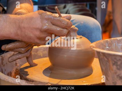 Le mani di un vasaio, creazione di un vaso di terracotta sul cerchio Foto Stock