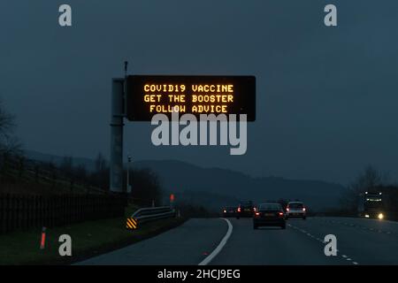 Scozia, Regno Unito. 29th Dic 2021. Il booster push di Covid-19 in Scozia include i segni giganti del gantry autostradale 'Covid-19 Get the Booster Follow Advice'. Nella foto - cartello sull'autostrada M74 in direzione nord verso Glasgow Credit: Kay Roxby/Alamy Live News Foto Stock