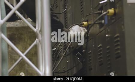 L'elettricista prova le installazioni elettriche e i fili sul sistema di protezione relè. Unità di controllo alloggiamento. Gruppo di comando a media tensione. Elettricista bui Foto Stock