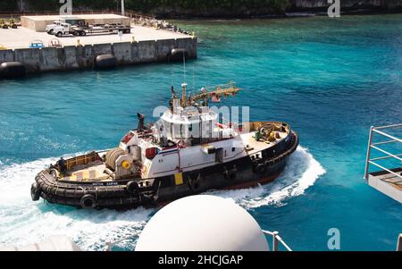 211228-N-MD461-1399 BASE NAVALE GUAM (DICEMBRE 28, 2021) Una nave rimorchiata si prepara ad assistere il vettore aereo di classe Nimitz USS Carl Vinson (CVN 70) nel ritiro dal porto quando la nave parte da Guam, 28 dicembre 2021. Carl Vinson Carrier Strike Group è in fase di implementazione programmata nell'area delle operazioni della flotta USA 7th per migliorare l'interoperabilità attraverso alleanze e partnership, fungendo da forza di risposta pronta a supportare una regione indopacifica libera e aperta. (STATI UNITI Foto Navy di Mass Communication Specialist 3rd Classe Jeff D. Kempton) Foto Stock