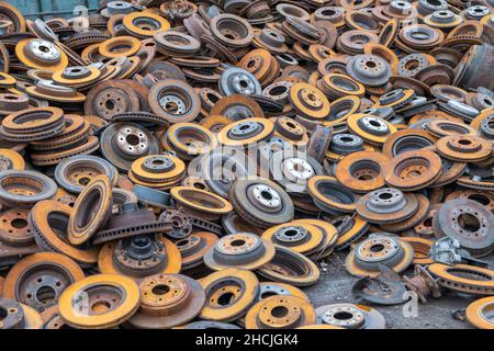 Vecchie ruote auto arrugginite in un deposito di metallo di scarto Foto Stock