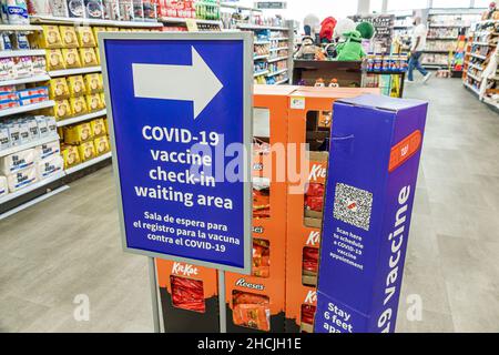 Miami Beach Florida Walgreens farmacia farmacia farmacia farmacia interna cartello avviso Covid-19 Vaccine check-in area d'attesa bilingue spagnolo inglese lingua Foto Stock