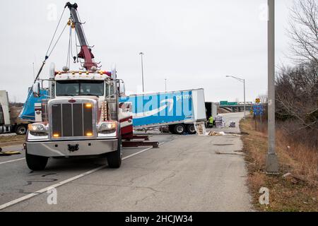 Kansas City, Kansas. Il camion che tirava il rimorchio Amazon prime pieno di cibo per cani è uscito dalla rampa della superstrada per accelerare e ribaltato sulla strada. Trainare il carrello con Foto Stock