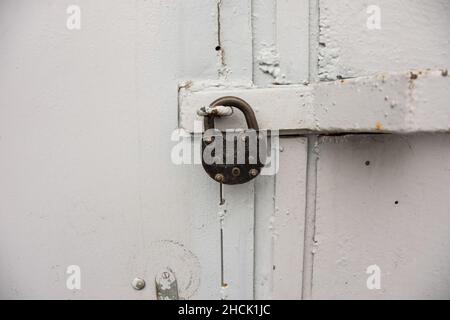 Vecchia porta in metallo bianco e serratura a fienile Foto Stock