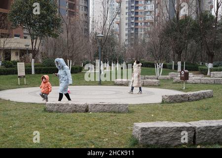 XI'AN, CINA - 30 DICEMBRE 2021 - i cittadini camminano in una comunità gated a Xi'an, capitale della provincia di Shaanxi della Cina nord-occidentale, 30 dicembre 2021. Foto Stock