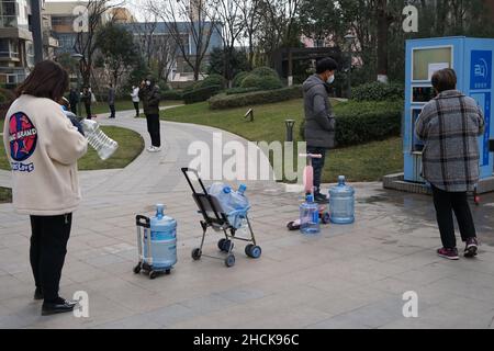 XI'AN, CINA - 30 DICEMBRE 2021 - i cittadini acquistano acqua purificata in una comunità gated a Xi'an, capitale della provincia di Shaanxi della Cina nordoccidentale, dicembre 30, Foto Stock