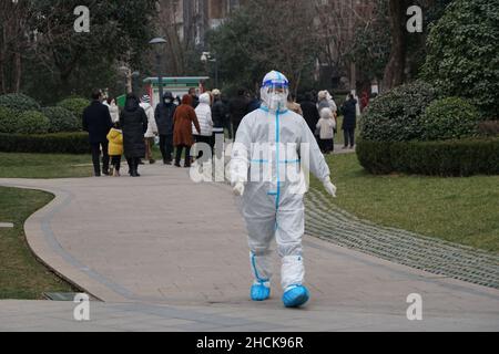 XI'AN, CINA - 30 DICEMBRE 2021 - gli operatori di prevenzione epidemica lavorano in una comunità gated a Xi'an, capitale della provincia di Shaanxi della Cina nordoccidentale, dicembre Foto Stock