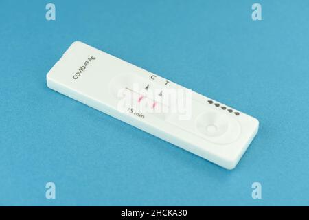 vista ravvicinata del test positivo dell'antigene covid-19 su sfondo blu Foto Stock
