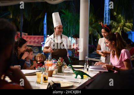 Sanya, la provincia cinese di Hainan. 28th Dic 2021. Daniele, proprietario e chef di un ristorante italiano, chiacchiera con gli ospiti al ristorante di Sanya, nella provincia di Hainan della Cina meridionale, 28 dicembre 2021. PER ANDARE CON 'Profilo: Lo chef italiano compie sogno in Cina isola resort ' Credit: Guo Cheng/Xinhua/Alamy Live News Foto Stock