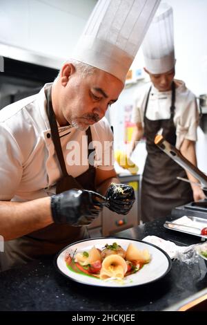 Sanya, la provincia cinese di Hainan. 28th Dic 2021. Daniele, proprietario e chef di un ristorante italiano, cucina al ristorante di Sanya, nella provincia di Hainan, nel sud della Cina, 28 dicembre 2021. PER ANDARE CON 'Profilo: Lo chef italiano compie sogno in Cina isola resort ' Credit: Guo Cheng/Xinhua/Alamy Live News Foto Stock