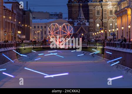 San Pietroburgo, Russia – 27 dicembre 2021: Colorato LED Heart e aurora polaris sul Ponte Italiano attraverso il canale di Griboyedov. Decorazioni per le vacanze Foto Stock