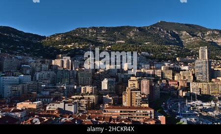 Bella vista panoramica del centro di Monaco sulla costa mediterranea nel pomeriggio luce del sole con denso sviluppo circondato da colline. Foto Stock