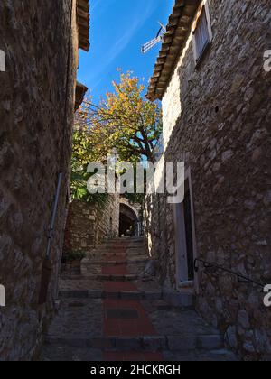 Splendida vista su un vicolo stretto nel centro storico del piccolo villaggio di Eze sulla Costa Azzurra, con tradizionali edifici in pietra in stile mediterraneo. Foto Stock