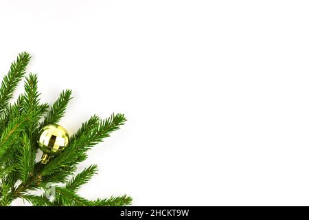 Natale palla giocattolo sfaccettato decorazione colore dorato su ramo di abete isolato su sfondo bianco Foto Stock