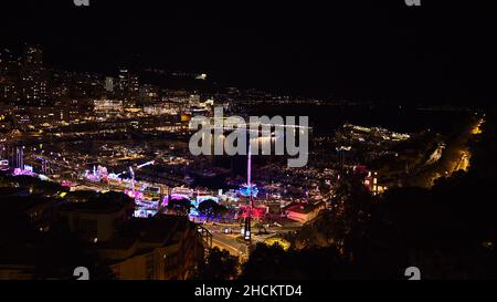 Splendida vista aerea notturna del porto di Port Hercule a Monaco con barche a vela di lusso ormeggiate sulla Costa Azzurra con funebre ed edifici illuminati. Foto Stock