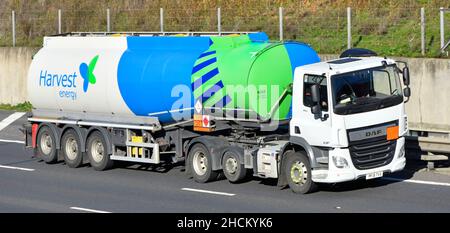 Harvest Energy colorata consegna carburante articolata rimorchio autocisterna e logo del marchio bianco DAF Truck hgv conducenti cabina lungo la strada autostradale del Regno Unito Foto Stock