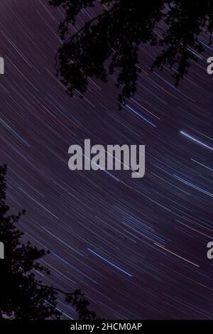 Scatto verticale di un cielo stellato con esposizione prolungata di notte, perfetto per sfondi Foto Stock