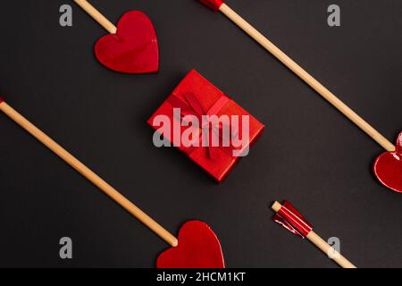 vista dall'alto delle frecce a forma di cuore vicino avvolte presente sul nero Foto Stock