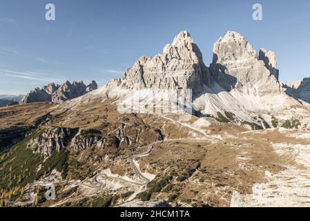 Il Rifugio Auronzo e le pareti rocciose meridionali delle tre Cime di Lavaredo illuminano nel sole della sera d'autunno, Dolomiti, Belluno, Italia Foto Stock