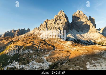 Il Rifugio Auronzo e le pareti rocciose meridionali delle tre Cime di Lavaredo illuminano nel sole della sera d'autunno, Dolomiti, Belluno, Italia Foto Stock