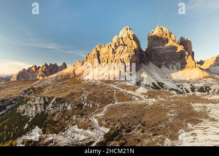 Il Rifugio Auronzo e le pareti rocciose meridionali delle tre Cime di Lavaredo illuminano nel sole della sera d'autunno, Dolomiti, Belluno, Italia Foto Stock