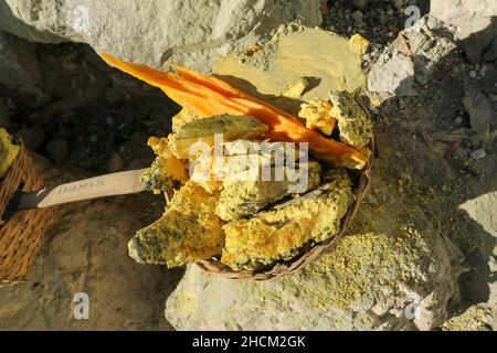 Cesto pesante caricato da pezzi di zolfo naturale per trasportare da minatori dalla miniera del cratere. Operazione manuale di estrazione dello zolfo ad uso intensivo di manodopera a Kawah Ijen Foto Stock