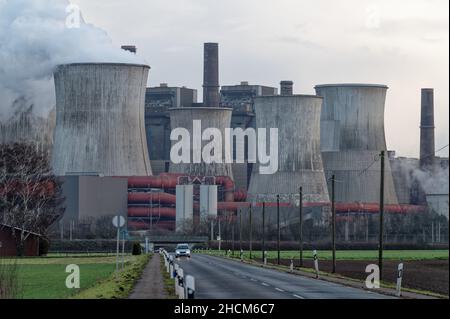 Essen, Germania. 28th Dic 2021. Le torri di raffreddamento della centrale elettrica Niederaussem di RWE stanno fumando di fronte all'edificio della centrale. Tre unità delle centrali elettriche a lignite di RWE saranno chiuse alla fine dell'anno. Credit: Henning Kaiser/dpa/Alamy Live News Foto Stock