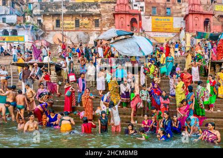 Varanasi, India - 11 novembre 2015. Pellegrini religiosi indiani in piedi su un ghat e bagno nel fiume Ganges, un importante rituale in Induismo. Foto Stock