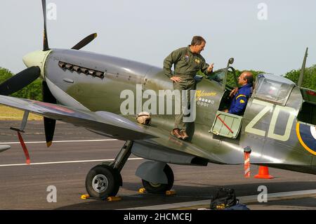 Il pilota Nigel Lamb permette ad un altro pilota di sedere nel secondo aereo da combattimento della seconda Guerra Mondiale Supermarine Spitfire IX MH434 a Biggin Hill, Kent, Regno Unito. Foto Stock