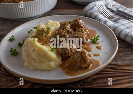 Polpetta svedese, chiamata köttbullar in una deliziosa salsa bruna servita con purè di patate su un piatto Foto Stock