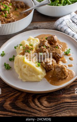 Polpetta svedese, chiamata köttbullar in una deliziosa salsa bruna servita con purè di patate su un piatto Foto Stock