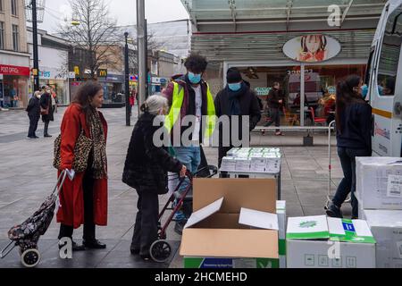 Slough, Berkshire, Regno Unito. 30th dicembre 2021. NHS Test and Trace e Solutions4Health sono stati nel Slough Town Center oggi dando libero Covid-19 Lateral Flow Self Testing Kit in scatole con 7 o 20 test. Data la scarsità ampiamente segnalata di test di flusso laterale Covid-19, alcune persone stavano prendendo borse piene dei kit di test multi pack 20. Le confezioni di auto-test Rapid Covid-19 (antigene) del gene Orient sono state contrassegnate come non destinate alla rivendita. Credit: Maureen McLean/Alamy Live News Foto Stock