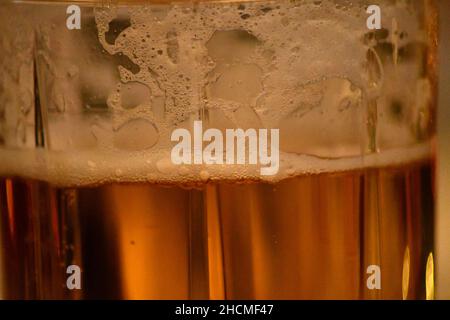 Un bicchiere di vera e propria birra che mostra la riduzione della schiuma mentre la birra viene bevuta Foto Stock