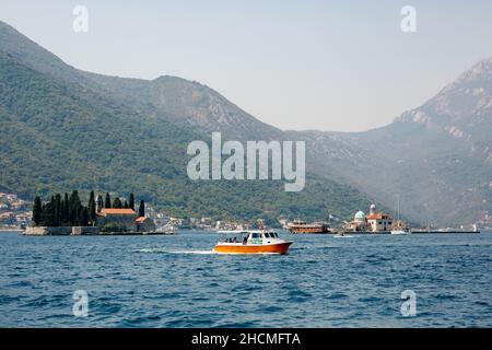 La barca da diporto passa davanti all'isola di San Giorgio nella baia di Cattaro Foto Stock