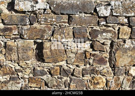 Muro di pietra medievale del castello di Aljezur, Portogallo. Motivo di texture di sfondo. Foto Stock
