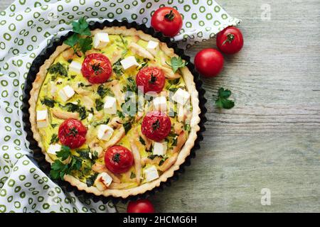 Torta di quiche con carne di pollo, pomodori, spinaci e formaggio. Foto Stock