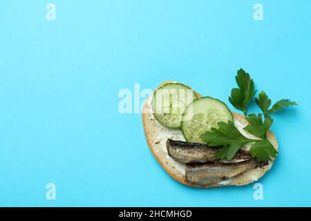 Gustoso sandwich con spratti su sfondo blu Foto Stock