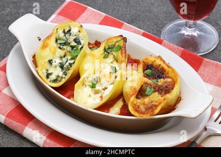 Conchiglioni ripieni di ragu, ricotta e spinaci. Cucina italiana Foto Stock