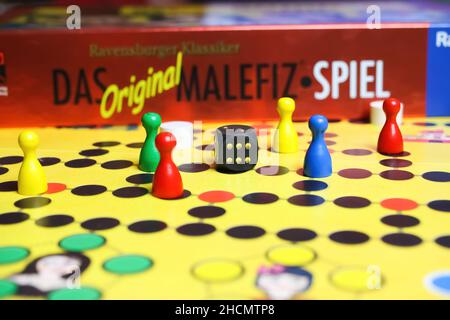 Viersen, Germania - Maggio 9. 2021: Vista sul tabellone giallo con figure colorate e dadi di ravensburger vecchio gioco di strategia da tavolo malefici Foto Stock