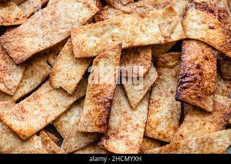 Tortilla di zucchero alla cannella appena sfornata Chips snack Food: Un mucchio di tortilla di zucchero alla cannella croccante sfornata Foto Stock