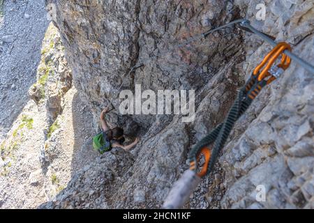 Primo piano di un rampicante via ferrata. Sullo sfondo un arrampicatore, nelle Dolomiti Foto Stock