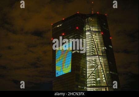 30 dicembre 2021, Hessen, Francoforte sul meno: Durante una prova, il numero '20' è proiettato sulla facciata sud della sede centrale della Banca centrale europea (BCE) nella zona est di Francoforte. La vigilia di Capodanno 20 anni fa, la moneta unica europea, l'euro, è stata introdotta in dodici paesi dell'UE. Per la Germania, questo significava dire Arrivederci al Marco D. Dal 31 dicembre 2021 al 9 gennaio 2022, la facciata della BCE sarà illuminata nelle ore serali. Foto: Arne Dedert/dpa Foto Stock