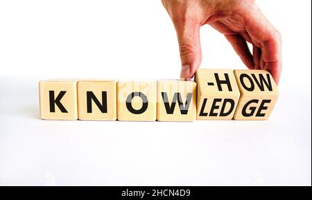 Simbolo di conoscenza e know-how. L'uomo d'affari trasforma i cubi, cambia la parola know-how in conoscenza. Bellissimo sfondo bianco, spazio di copia. Affari, sapere Foto Stock