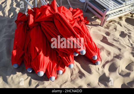 Ombrelloni rossi accatastati sulla sabbia, alla fermata 16 di Playa Mansa. Punta del Este, Maldonado, Uruguay. Foto Stock