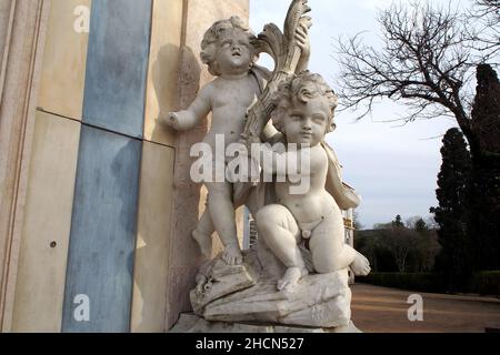 Scultura di un poupons che porta un mazzo di spighe di grano, decorazione della facciata del Palazzo Queluz, vicino Lisbona, Portogallo Foto Stock