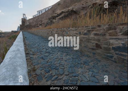 Rampa lungo le mura esterne che conducono alla torre dell'orologio del centro storico di Mertola, Alentejo, Portogallo Foto Stock